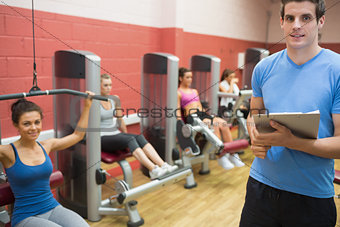 Trainer in weights room with women