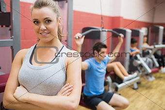 Smiling female trainer with arms crossed