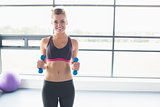 Woman lifting weights in fitness studio