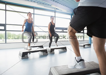 Trainer stepping with aerobics class