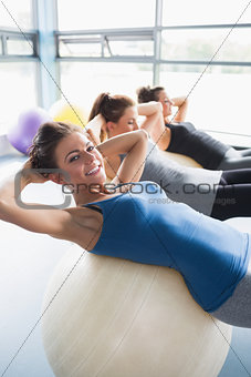 Smiling women doing sit-ups