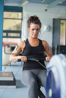 Exhausted woman training on row machine