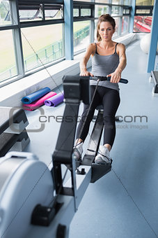 Brunette woman training on row machine