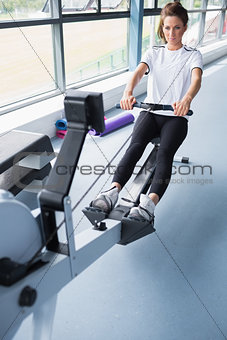 Energetic woman training on row machine