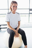 Smiling woman sitting on exercise ball