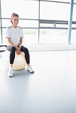 Woman smiling while sitting on exercise ball