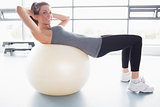 Woman doing sit-ups on exercise ball