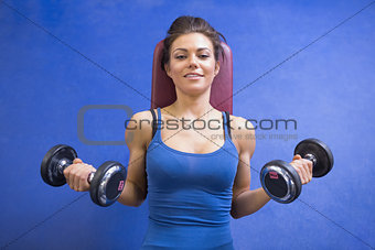Woman lifting weights while lying