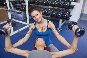 Woman teaching lifting weights and smiling