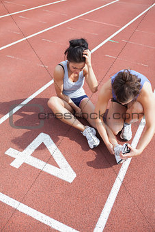 Woman caring about runner with sports injury