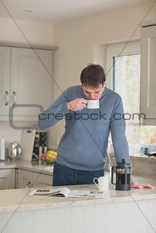 Young man having a coffee in the kitchen