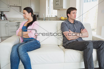 Two people sitting on the couch and having a dispute