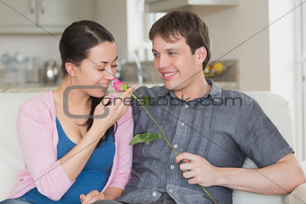 Man presenting flower to girlfriend