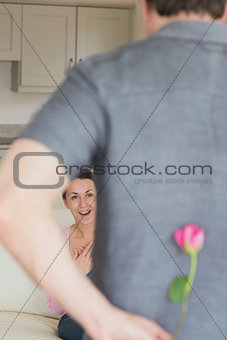 Man hiding flower behind his back for wife