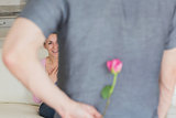 Husband hiding flower behind back