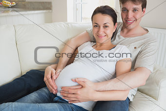 Expecting couple lying on couch