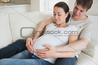 Expectant parents relaxing on the couch