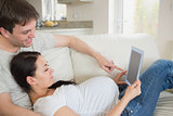 Prospective parents relaxing with tablet pc