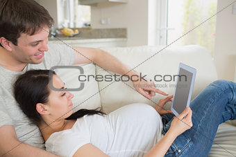 Prospective parents relaxing with tablet pc