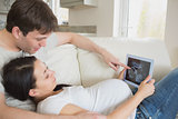 Prospective parents looking at ultrasound scan on tablet pc