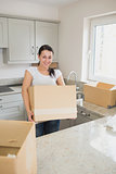 Smiling woman holding a moving box