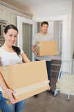 Young couple holding moving boxes