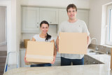Young man and woman holding moving boxes
