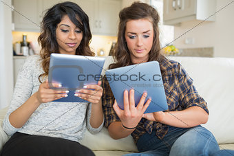 Two women holding and looking at tablet computers