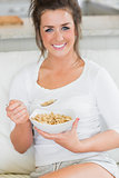 Smiling girl eating bowl of cereal