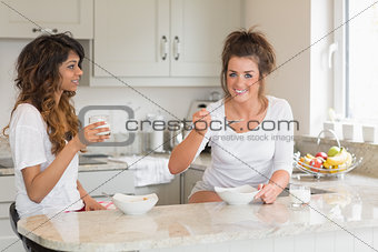 Two friends eating bowls of cereal