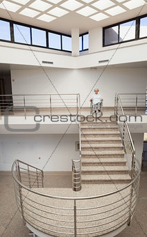 Elderly lady in wheelchair at top of stairwell