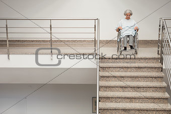 Elderly lady in wheelchair at top of stairs