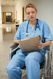 Nurse consulting file sitting in a wheelchair