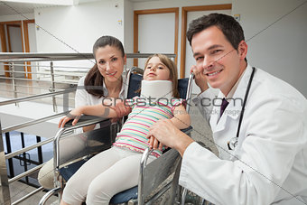 Smiling doctor, mother and her child in wheelchair