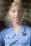 Young female doctor with blurred x-ray background