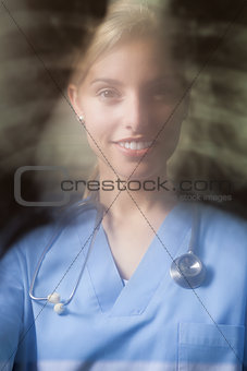 Young female doctor with blurred x-ray background