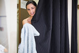 Woman standing behind curtain in changing room