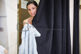 Woman standing behind curtain in changing room