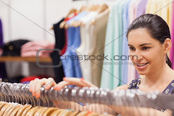 Woman sorting clothes on rail