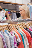 Woman standing at the clothes rack showing clothes