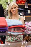 Woman standing at a clothes rack smiling