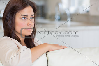 Woman on sofa looking thoughtful
