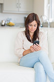 Woman sitting on the couch using her mobile phone