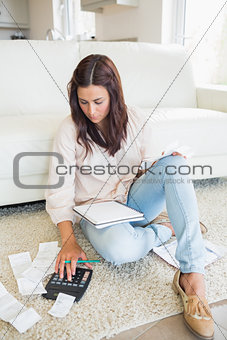 Woman sitting on the carpet checking bills