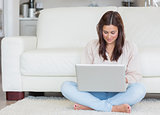 Woman sitting on the carpet with her laptop