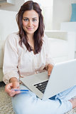 Woman holding a credit card and a laptop