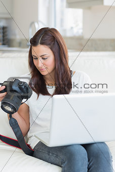 Woman viewing photos while holding a laptop