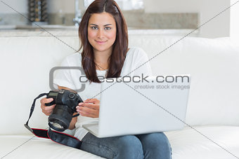Brunette holding laptop and camera