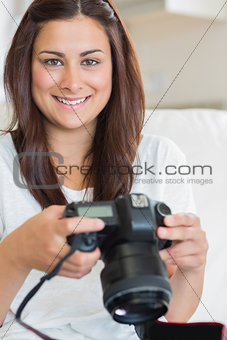 Brunette woman holding digital camera