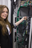 Smiling girl working on rack mounted servers